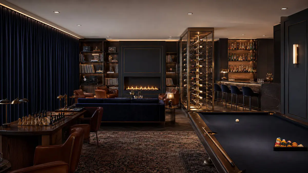 The club lounge with a fireplace, a billiard table and a wine cabinet